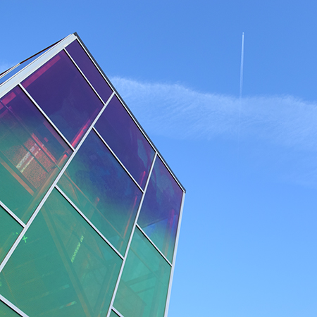 Vattenhallens regnbågsfärgade trapphus mot en blå himmel. Foto.
