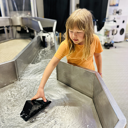 Flicka som utforskar Vattenkraftverket på Vattenhallen. Foto.